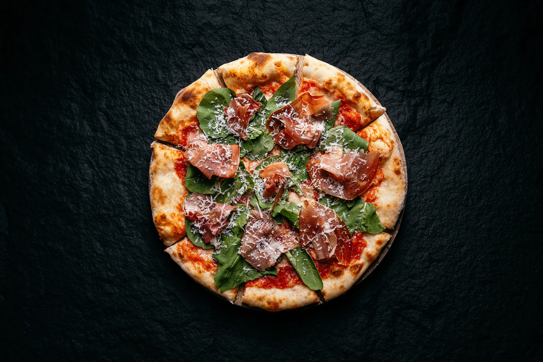 Pizza fotografiada sobre un fondo oscuro