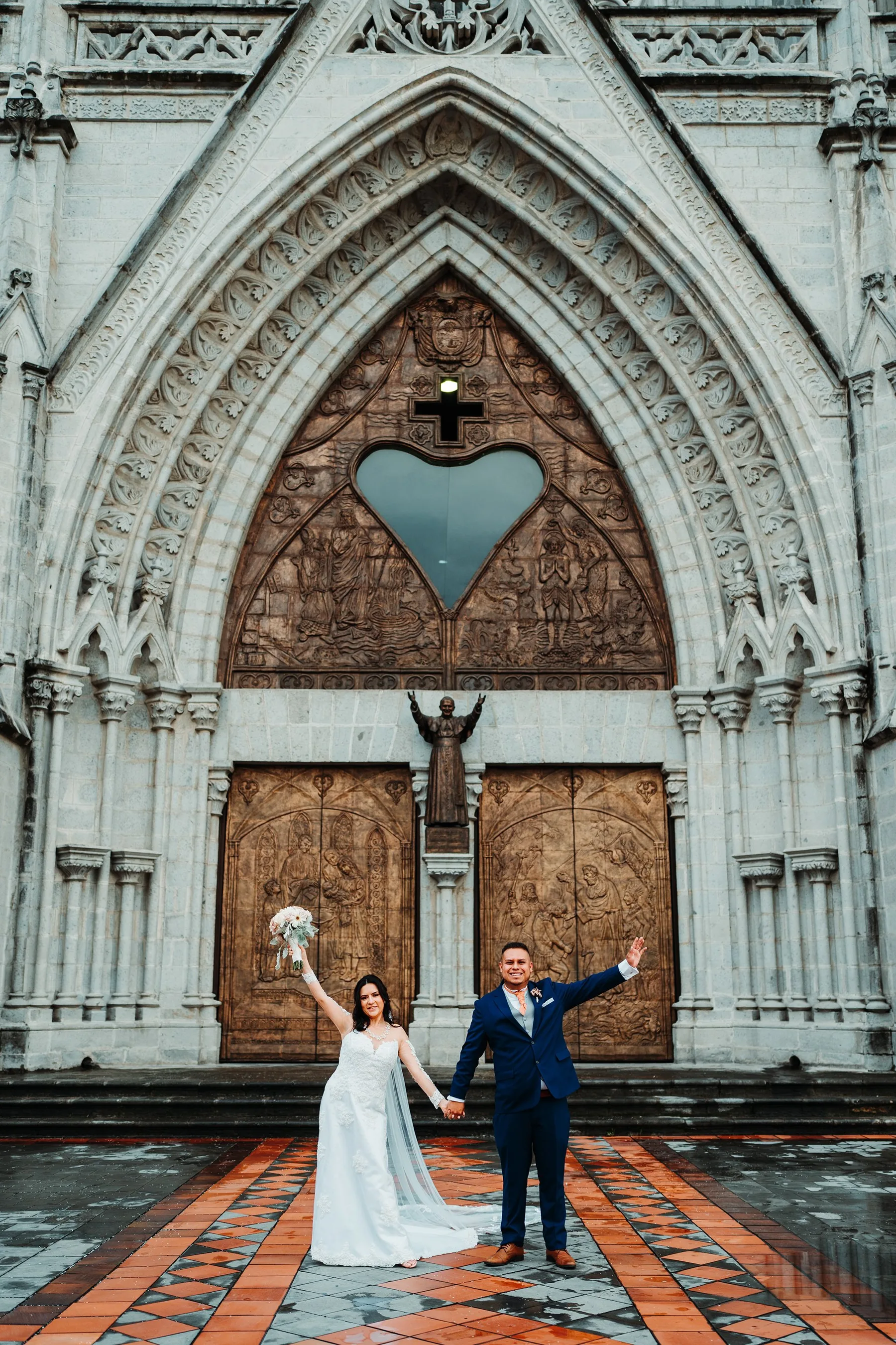 Novios celebrando frente a la fachada de la iglesia